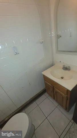 a bathroom with a granite countertop toilet and a sink