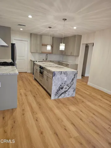 a kitchen with stainless steel appliances granite countertop a stove a sink and a refrigerator