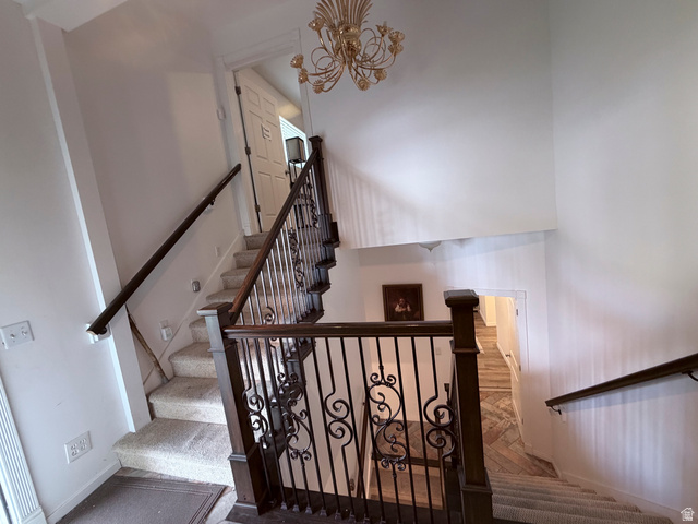 2855 South 1000 West Perry, UT 84302 - Photo 97 of 142 Staircase featuring a high ceiling, a chandelier, and carpet flooring