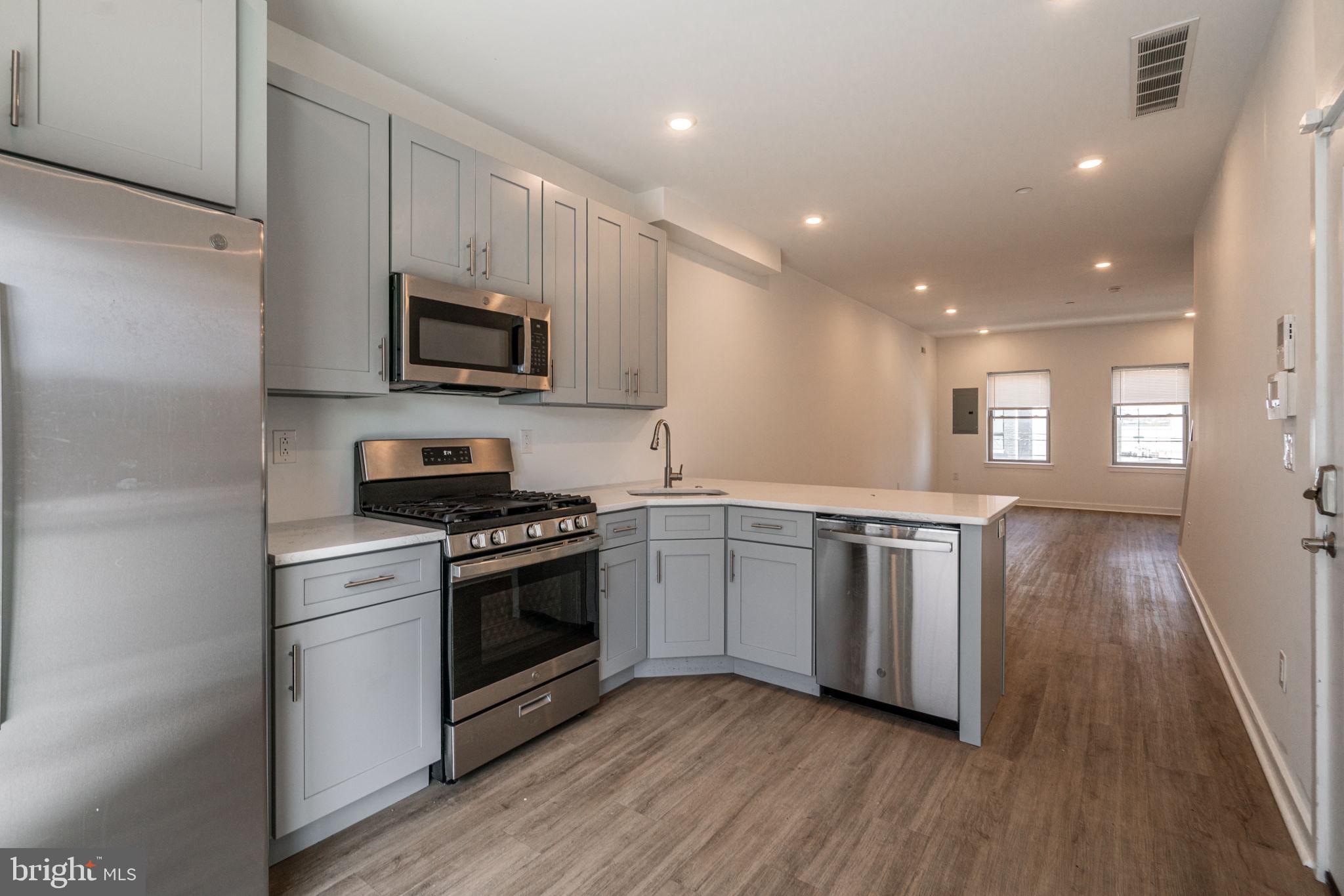 1105 South 27th Street Philadelphia, PA 19146 - Photo 8 of 19 a kitchen with stainless steel appliances granite countertop a stove a sink and a microwave