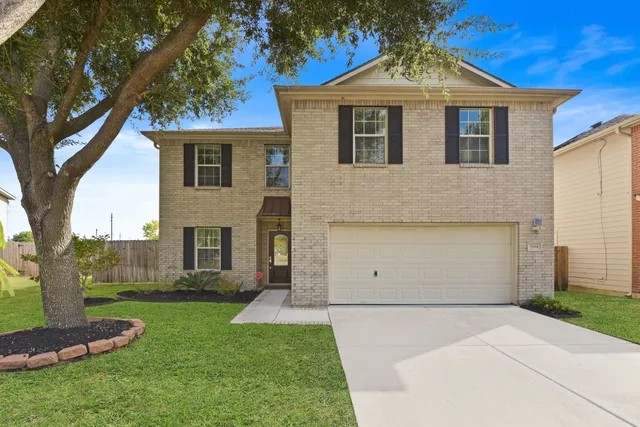 a front view of a house with a yard and a garage