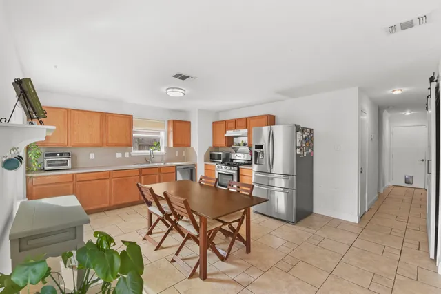 a kitchen with stainless steel appliances kitchen island granite countertop a refrigerator and a stove top oven
