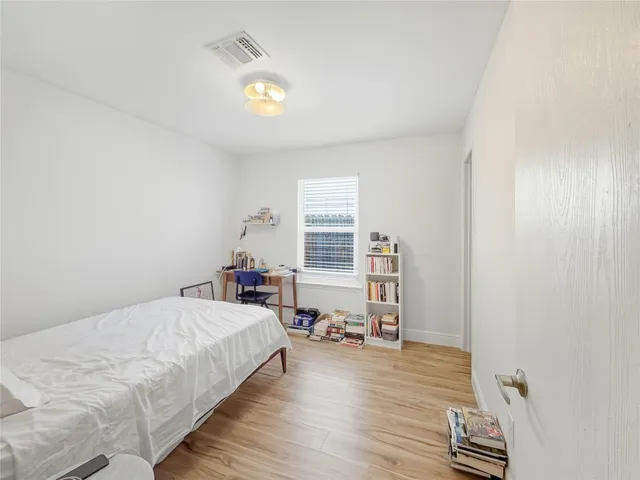 a bedroom with a bed and wooden floor