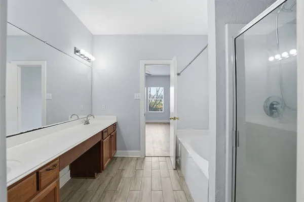 a bathroom with a tub sink and mirror