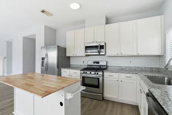 a kitchen with white cabinets sink and stainless steel appliances