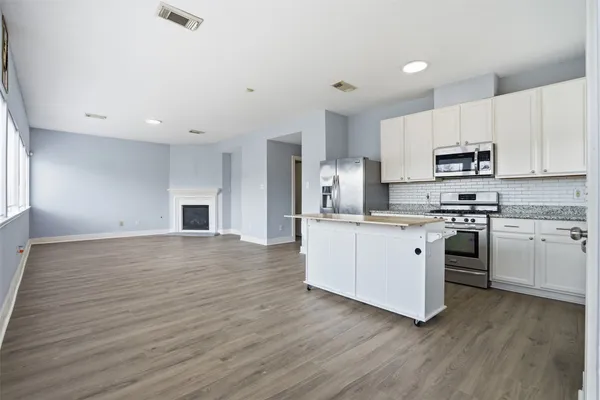 a kitchen with granite countertop white cabinets and stainless steel appliances