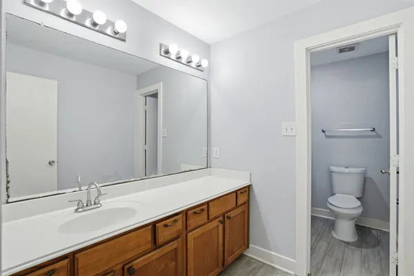a spacious bathroom with a granite countertop sink a toilet and a mirror