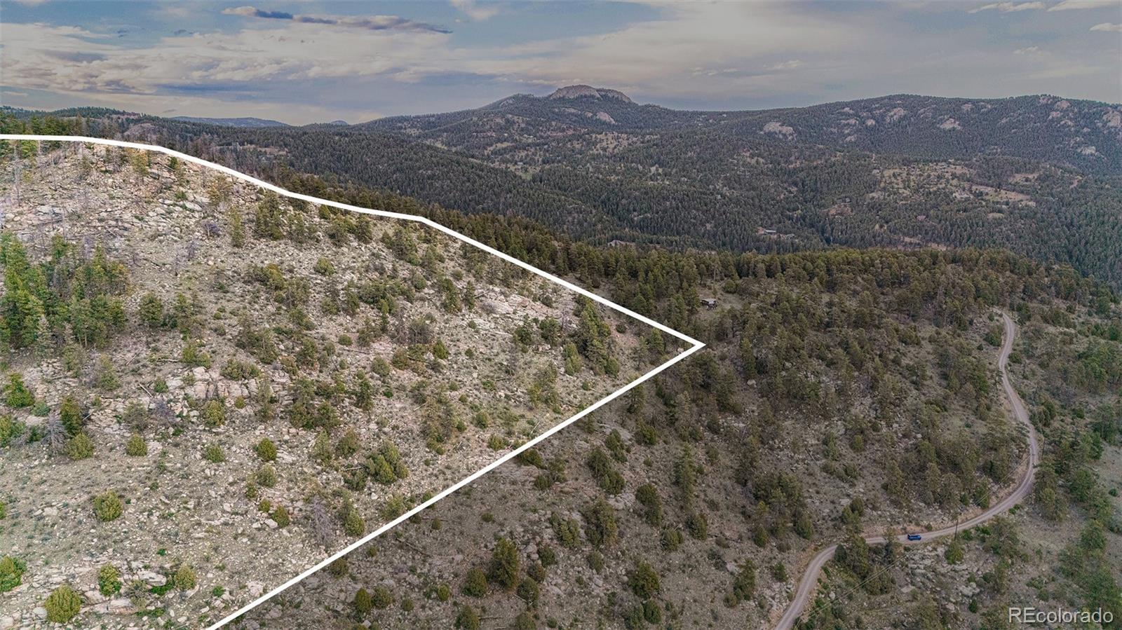 14336 South Wamblee Trail Conifer, CO 80433 - Photo 5 of 12 a view of a dry yard with mountains in the background