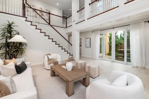 a living room with couches and a dining table with wooden floor