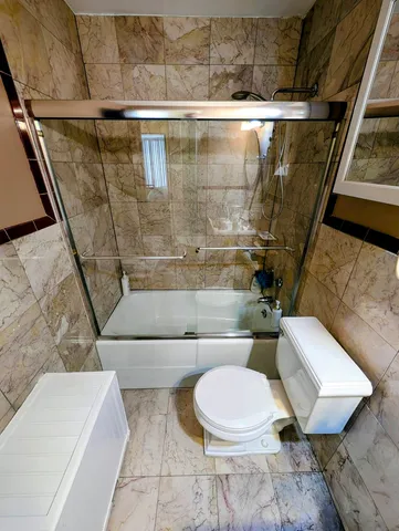 a white toilet sitting next to a bath tub
