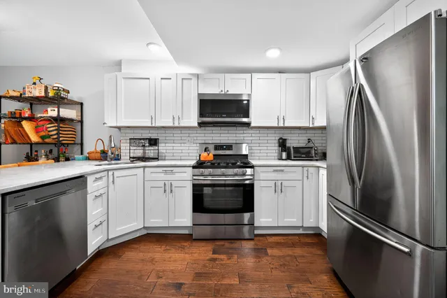 a kitchen with a refrigerator sink and white cabinets