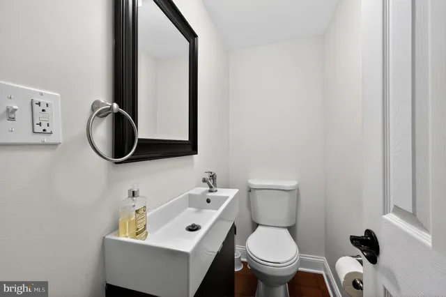 a bathroom with a toilet sink and mirror