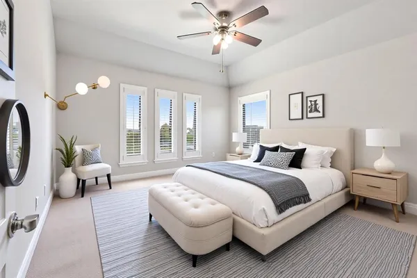 a spacious bedroom with a bed couch and windows