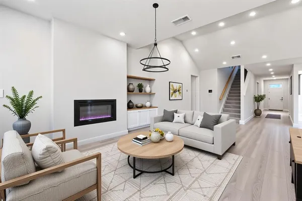 a living room with furniture and a chandelier