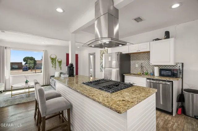a kitchen with stainless steel appliances granite countertop a stove and a refrigerator