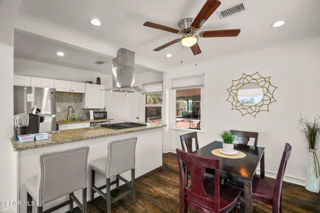a kitchen with a dining table cabinets stainless steel appliances and a chandelier