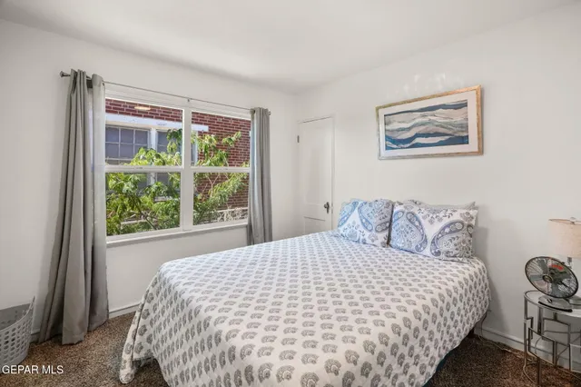 a large bed sitting in a bedroom next to a window