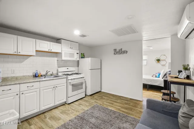 a kitchen with granite countertop a sink cabinets stainless steel appliances and a window