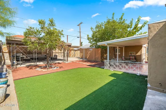 a view of a house with backyard and sitting area