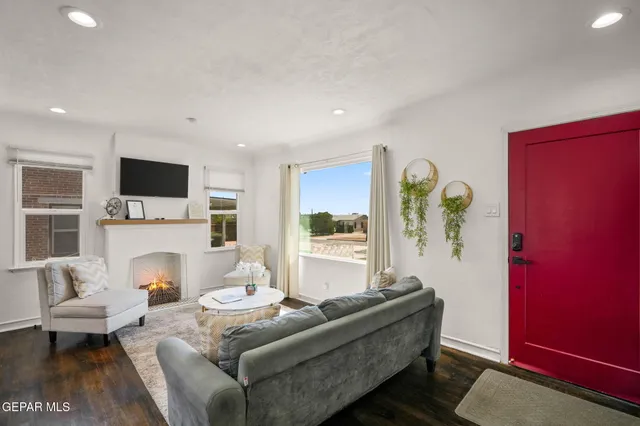 a living room with furniture a fireplace and a flat screen tv