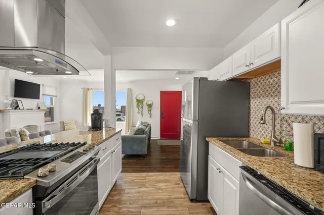 a kitchen with stainless steel appliances granite countertop a sink stove and refrigerator