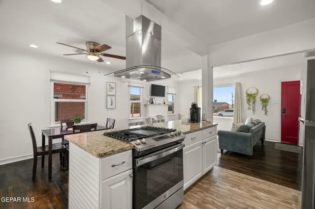 a kitchen with stainless steel appliances granite countertop a stove and a wooden floors