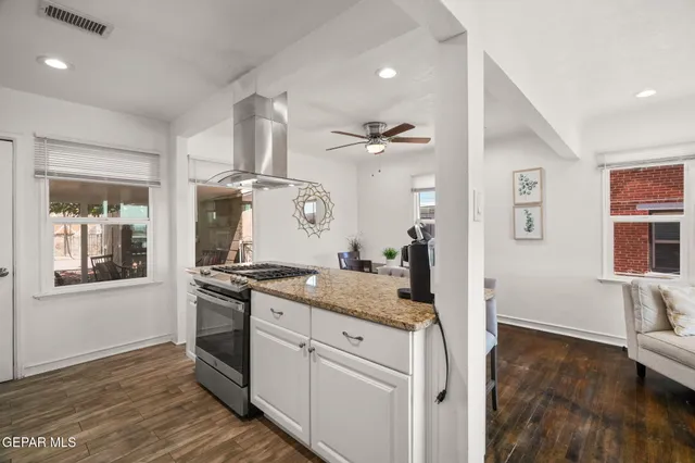 a kitchen with granite countertop cabinets stainless steel appliances and a wooden floor