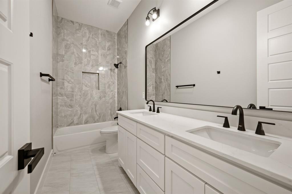 806 N Avenue East Springtown, TX 76082 - Photo 19 of 25 a bathroom with a double vanity sink toilet mirror and bathtub