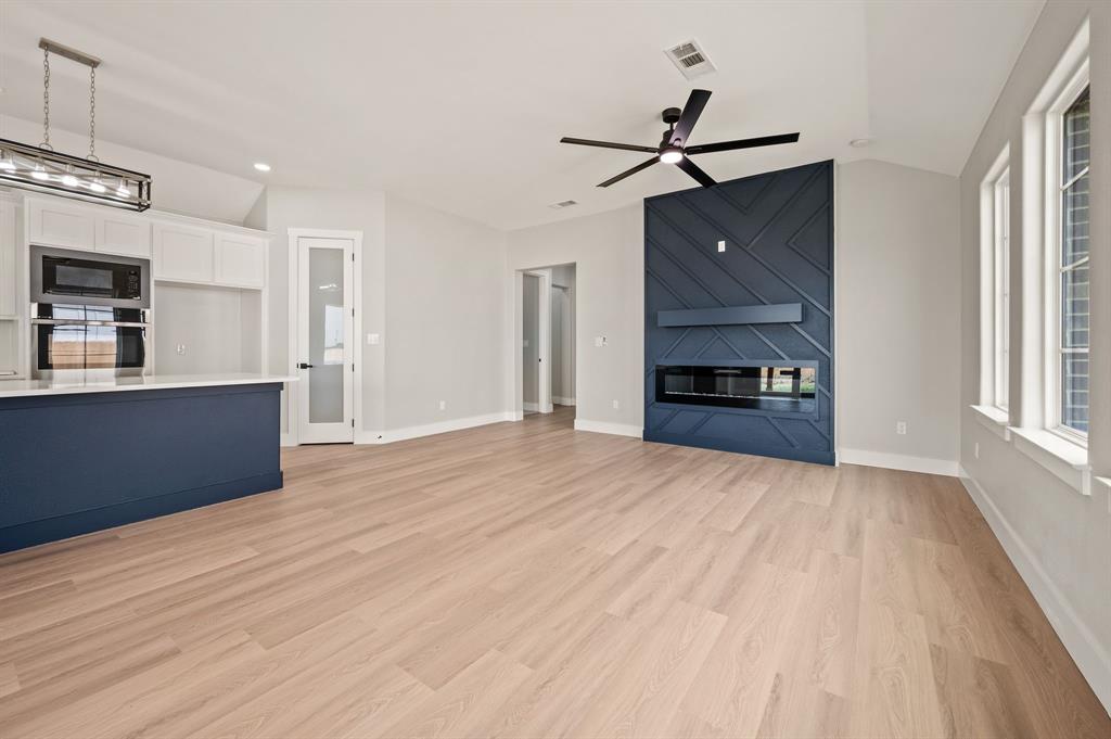 806 N Avenue East Springtown, TX 76082 - Photo 5 of 25 a view of a kitchen with wooden floor and a ceiling fan