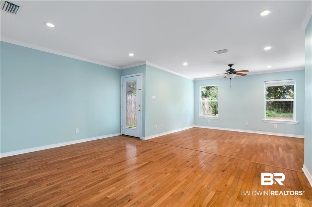 218 Grand Boulevard Mobile, AL 36607 - Photo 7 of 22 Spare room with ceiling fan, crown molding, and wood-type flooring