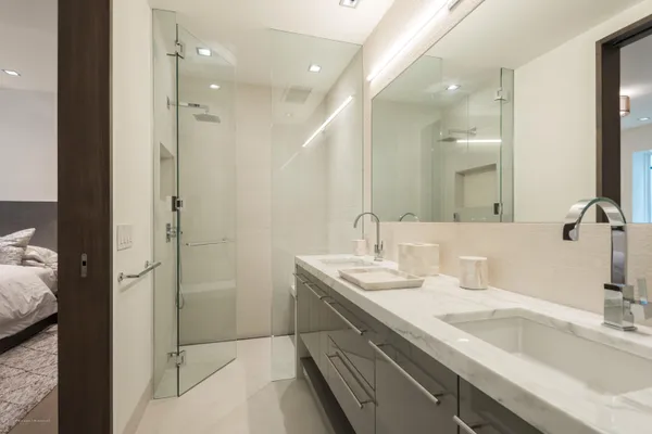 a bathroom with a double vanity sink mirror and shower