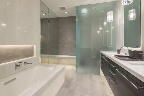 a spacious bathroom with a tub sink shower and mirror