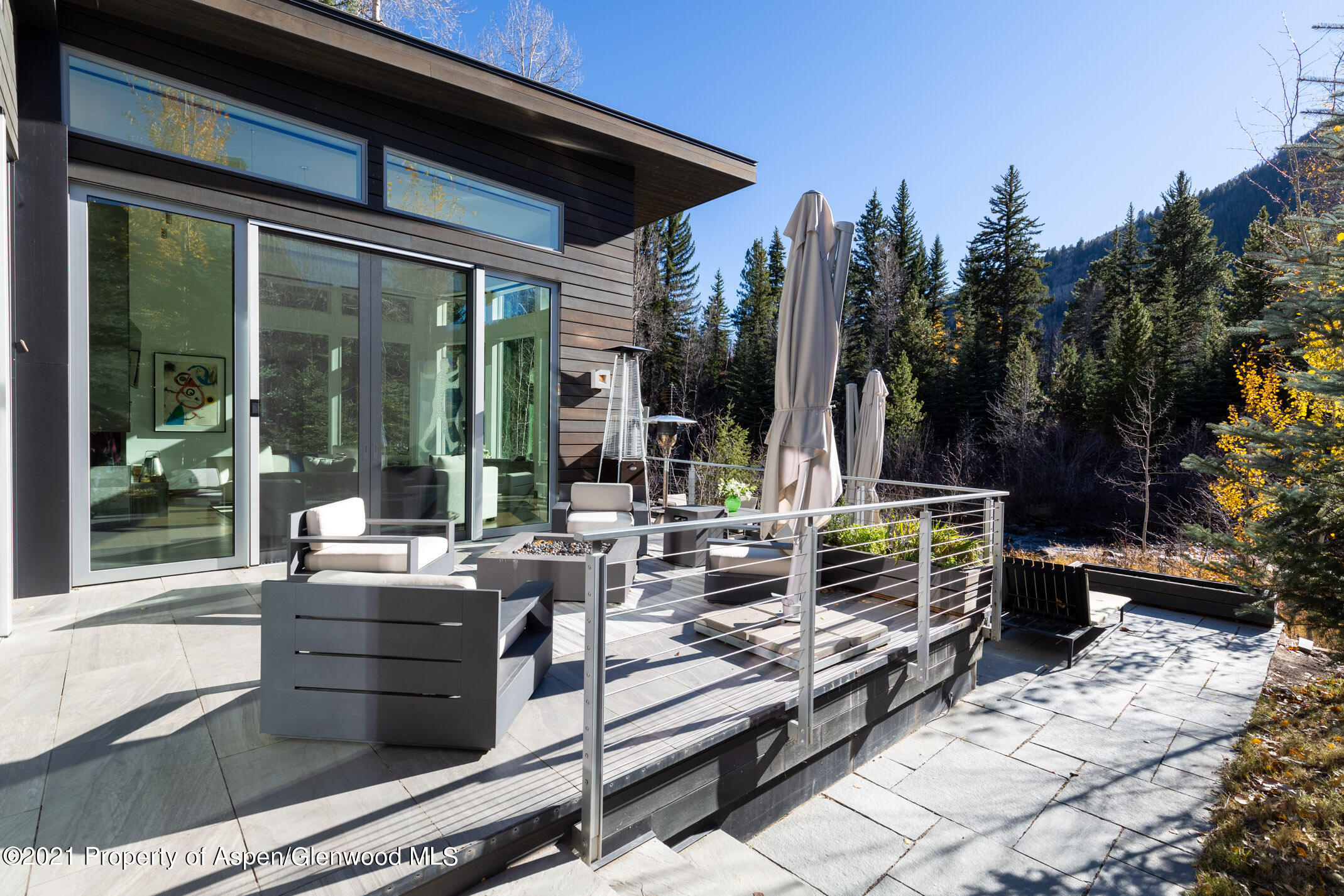 79 Winter Way Aspen, CO 81611 - Photo 25 of 40 a view of a patio with table and chairs potted plants and floor to ceiling window