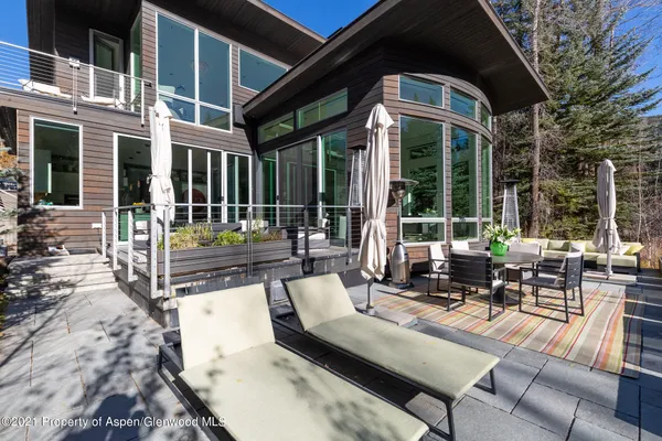 a view of a patio with couches table and chairs and wooden floor