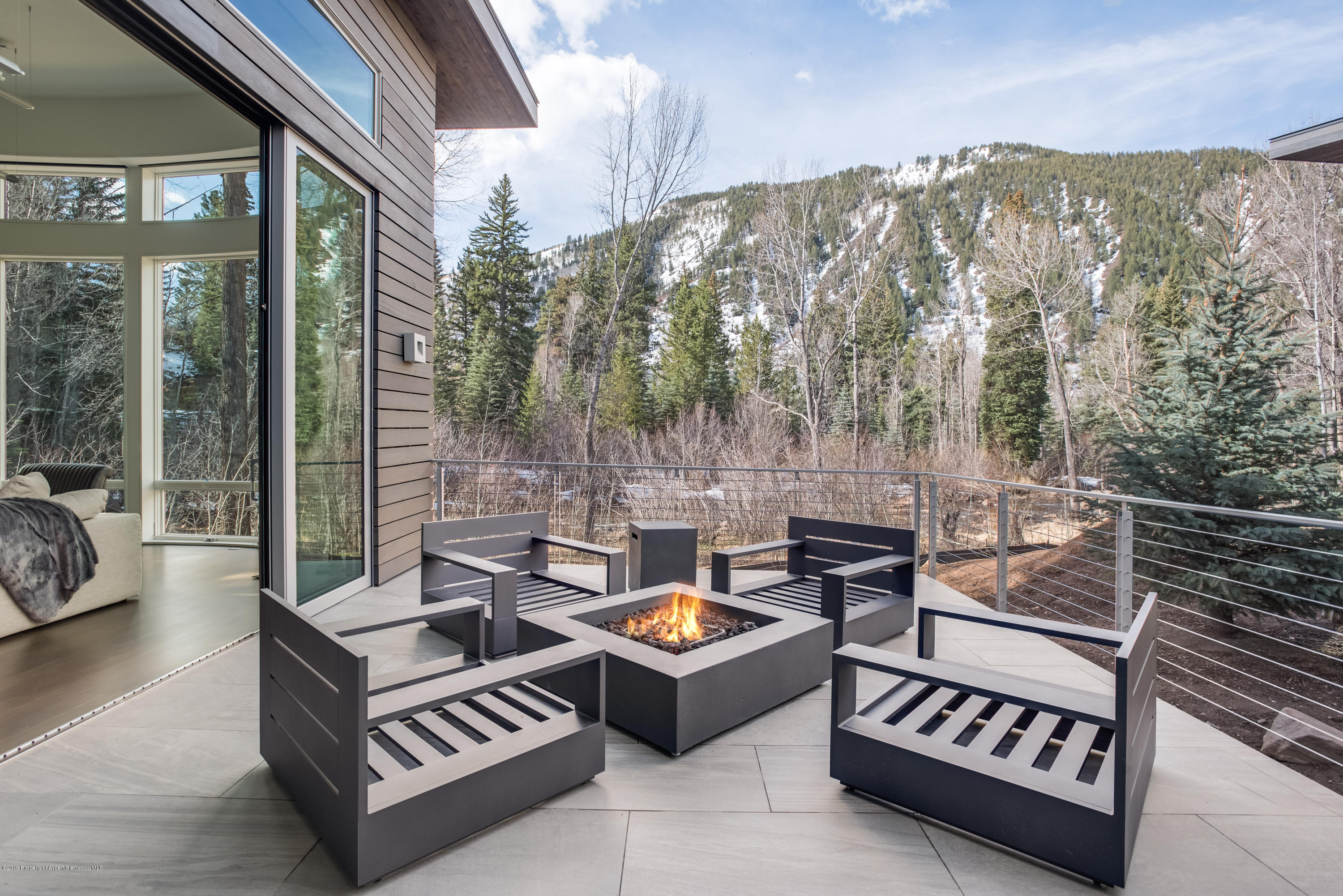 79 Winter Way Aspen, CO 81611 - Photo 36 of 40 a view of a patio with couches and a table and chairs with wooden floor