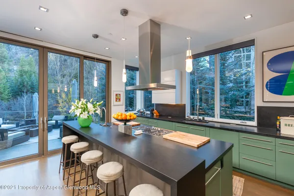 a kitchen with a table chairs sink and wooden floor