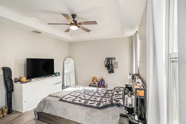 a bedroom with bed and a flat tv screen on dresser