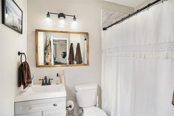 a bathroom with a toilet sink and mirror