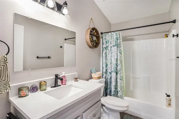 a bathroom with a sink a toilet and shower curtain