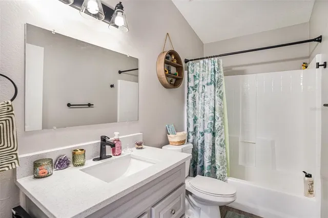 a bathroom with a sink a toilet and shower curtain