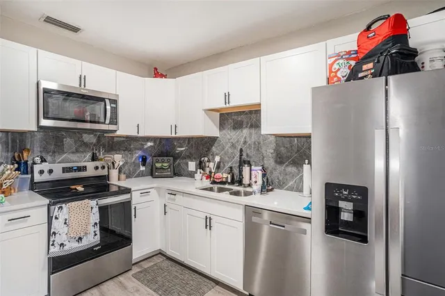 a kitchen with a refrigerator stove and sink