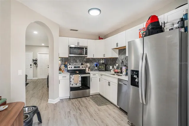 a kitchen with stainless steel appliances granite countertop a refrigerator sink and stove
