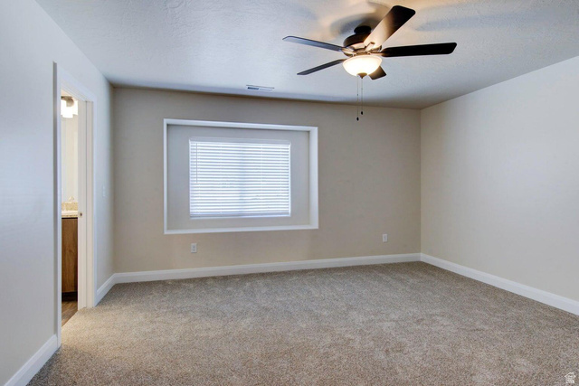 668 East Fiddlers Canyon Road, Unit 24 Cedar City, UT 84721 - Photo 6 of 21 Spare room with light colored carpet, ceiling fan, and a textured ceiling