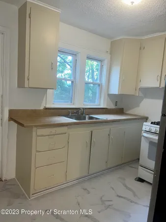a kitchen with a refrigerator and a stove top oven