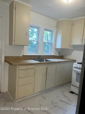 a kitchen with a refrigerator and a stove top oven