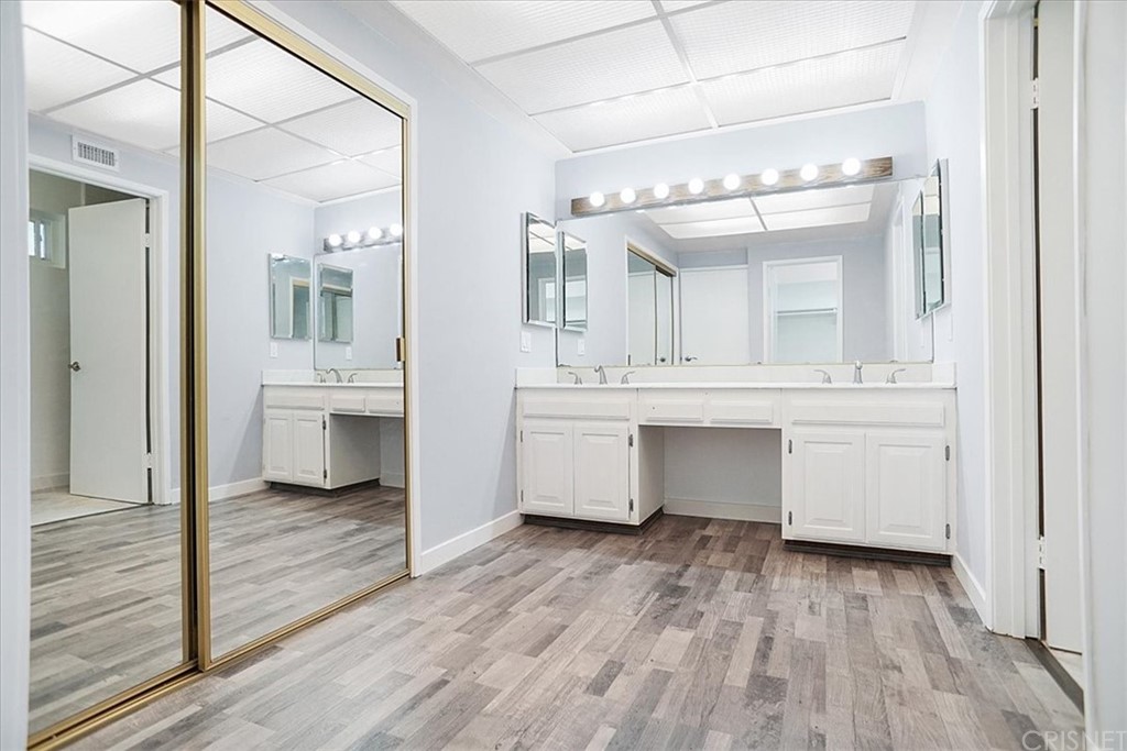 12230 Stewarton Drive Porter Ranch, CA 91326 - Photo 15 of 25 a view of a hallway with wooden floor and a cabinet