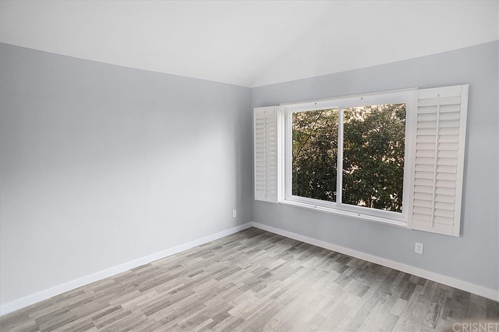 12230 Stewarton Drive Porter Ranch, CA 91326 - Photo 19 of 25 an empty room with wooden floor and windows