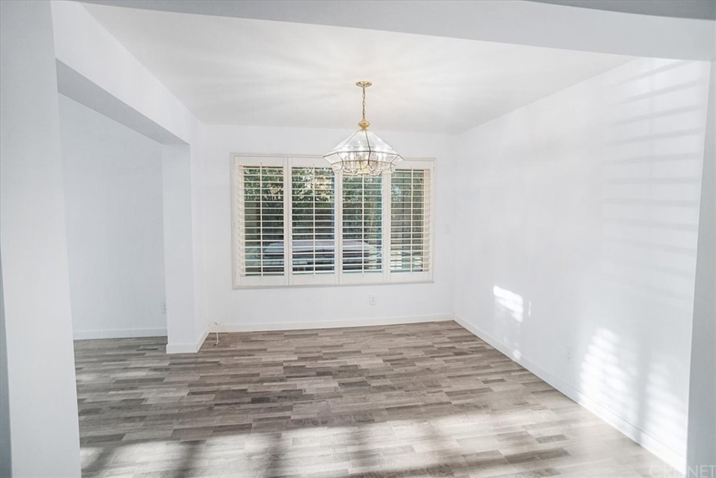 12230 Stewarton Drive Porter Ranch, CA 91326 - Photo 5 of 25 a view of an empty room with wooden floor and a window
