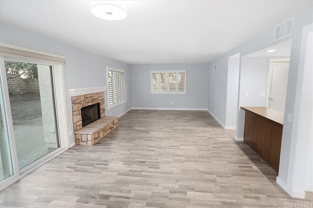 12230 Stewarton Drive Porter Ranch, CA 91326 - Photo 9 of 25 an empty room with fireplace and windows
