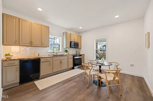a kitchen with a table chairs a sink dishwasher stove and cabinets